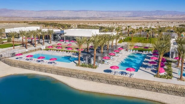 A resort with multiple swimming pools, sun loungers, and palm trees. - Sophisticated Resort/WFA Amenity-Filled PS Home (Palm Springs)