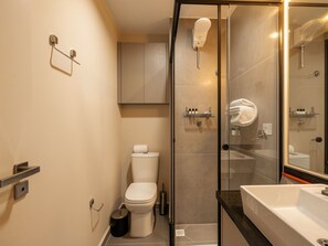 A modern bathroom with a glass-enclosed shower, a toilet, a sink, and a towel rack. - Xtay Vila Madalena (São Paulo)