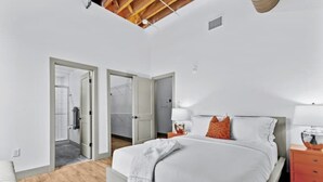 A bedroom with a bed, bedside tables, and a wardrobe. - Downtown Riverfront Loft Steps from Arch (St. Louis)