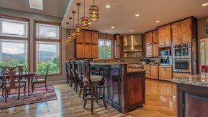 Una cocina moderna con armarios de madera, una isla central y vistas al exterior.