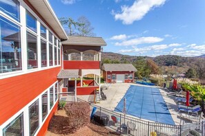 Enjoy a refreshing dip in the pool surrounded by a covered outdoor area with lounge chairs.