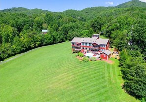 Situated in a lush valley, this property offers a serene setting with a well-maintained lawn and outdoor spaces.
