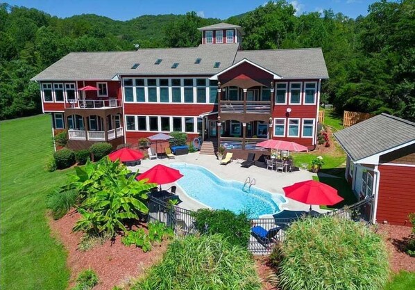Relax on the spacious deck with lounge chairs and umbrellas, surrounded by a landscaped garden and a central swimming pool.