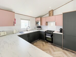 A modern kitchen with a sink, stove, and microwave.