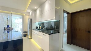 Una cucina moderna con mobili bianchi, un piano di lavoro nero e illuminazione sotto i pensili.