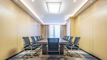 Una sala de conferencias con una larga mesa, sillas y piso alfombrado.