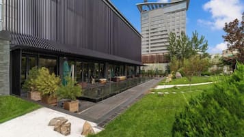 Een modern gebouw met een lange, overdekte buitenruimte en een zwembad.