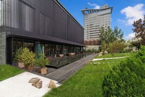 Un bâtiment moderne doté d’une longue terrasse extérieure couverte et d’une piscine.