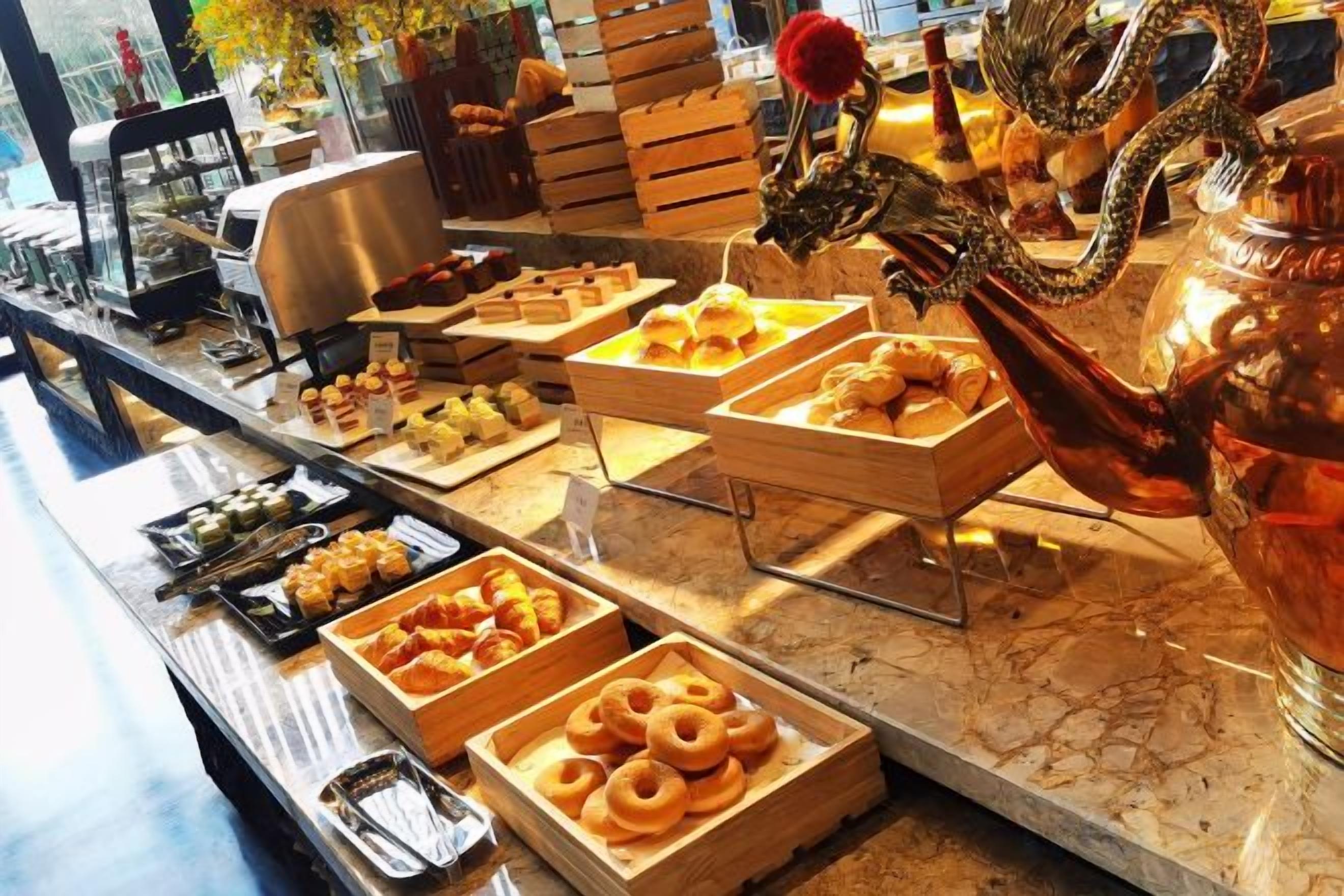 A buffet with various food items and a decorative dragon sculpture.