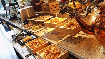 A buffet with various food items and a decorative dragon sculpture.