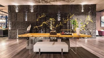 Un interior moderno con una pared de acento de piedra, una mesa de comedor de madera y un banco.