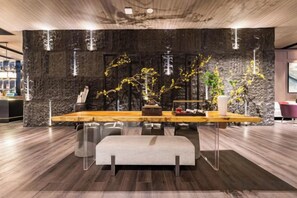 Un intérieur moderne avec un mur d’accent en pierre, une table à manger en bois et un banc.