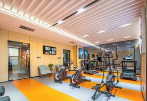 Een moderne sportschool met hometrainers, loopbanden en een spiegelwand.