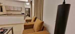 Relax in this stylish living space with a sofa, television, and kitchen area.