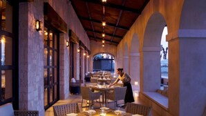 A restaurant with outdoor seating, tables set with plates and glasses, and a waiter attending to a table. - Cozy Oceanfront Resort Golf&SPA Suite Pacific Dunes San Lucas 4 p- 1 B./ 2 Bath (cabo san Lucas)
