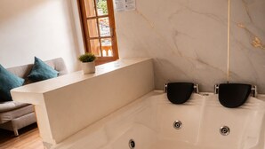 Une salle de bain moderne avec une baignoire sur pieds, un plancher en bois et une fenêtre offrant une belle vue.