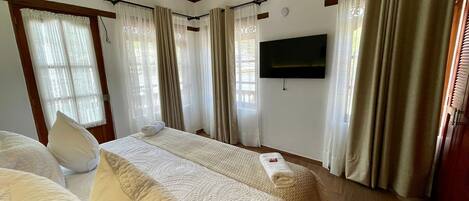 Habitación de hotel con una cama grande, un televisor de pantalla plana y techo de madera.