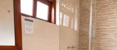 A bathroom with a toilet, sink, and shower.