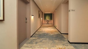 Pasillo de hotel con piso alfombrado, una recepción y una puerta con la etiqueta "8816".