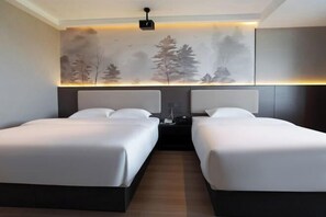 A hotel room with two beds, a nightstand, and a wall-mounted projector. - Zhuzhou City Place. Yue Hotel (Zhuzhou)