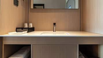 Un baño moderno con un espejo grande, un lavabo y un perchero para toallas.