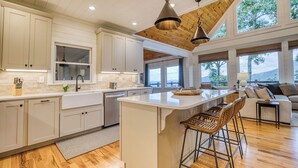 A spacious kitchen with a large island, wooden flooring, and a view of the outdoors. - Breathtaking Views-Ping Pong-Video Games- Hot Tub (Blue Ridge)