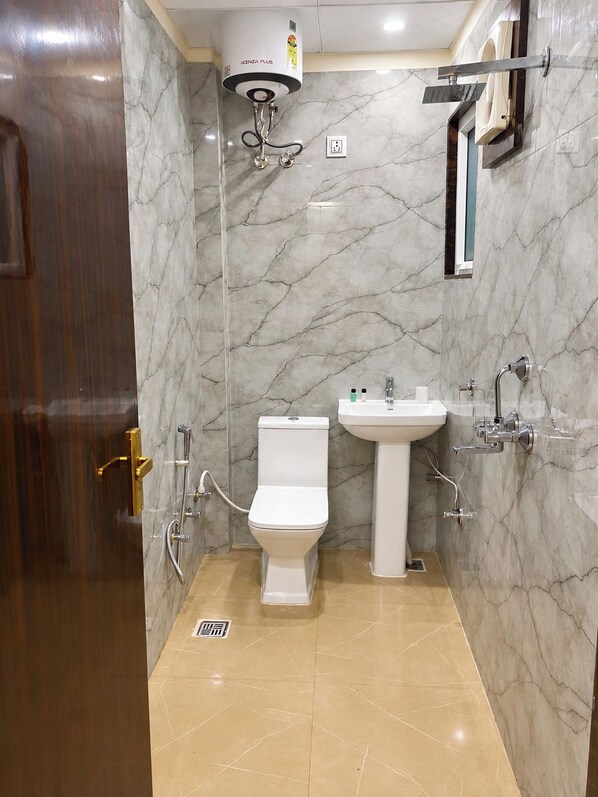 Une salle de bain avec des toilettes, un lavabo et une douche.