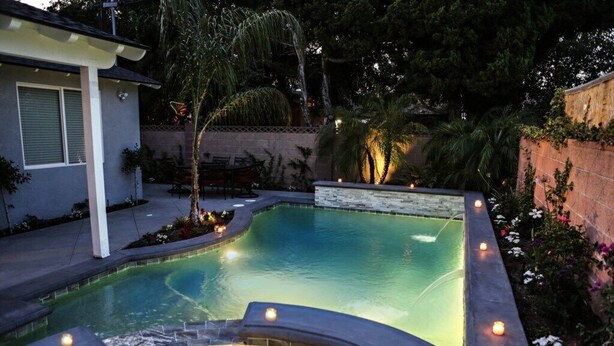 A swimming pool with a hot tub, surrounded by a patio area with outdoor furniture. - Fantastic 6 bedroom 4 bath Pool Home (Anaheim)
