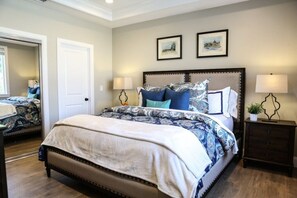 A bedroom with a bed, bedside tables, and a door.