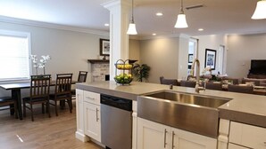 A modern kitchen with a dishwasher, a stainless steel sink, and pendant lighting. - Fantastic 6 bedroom 4 bath Pool Home (Anaheim)