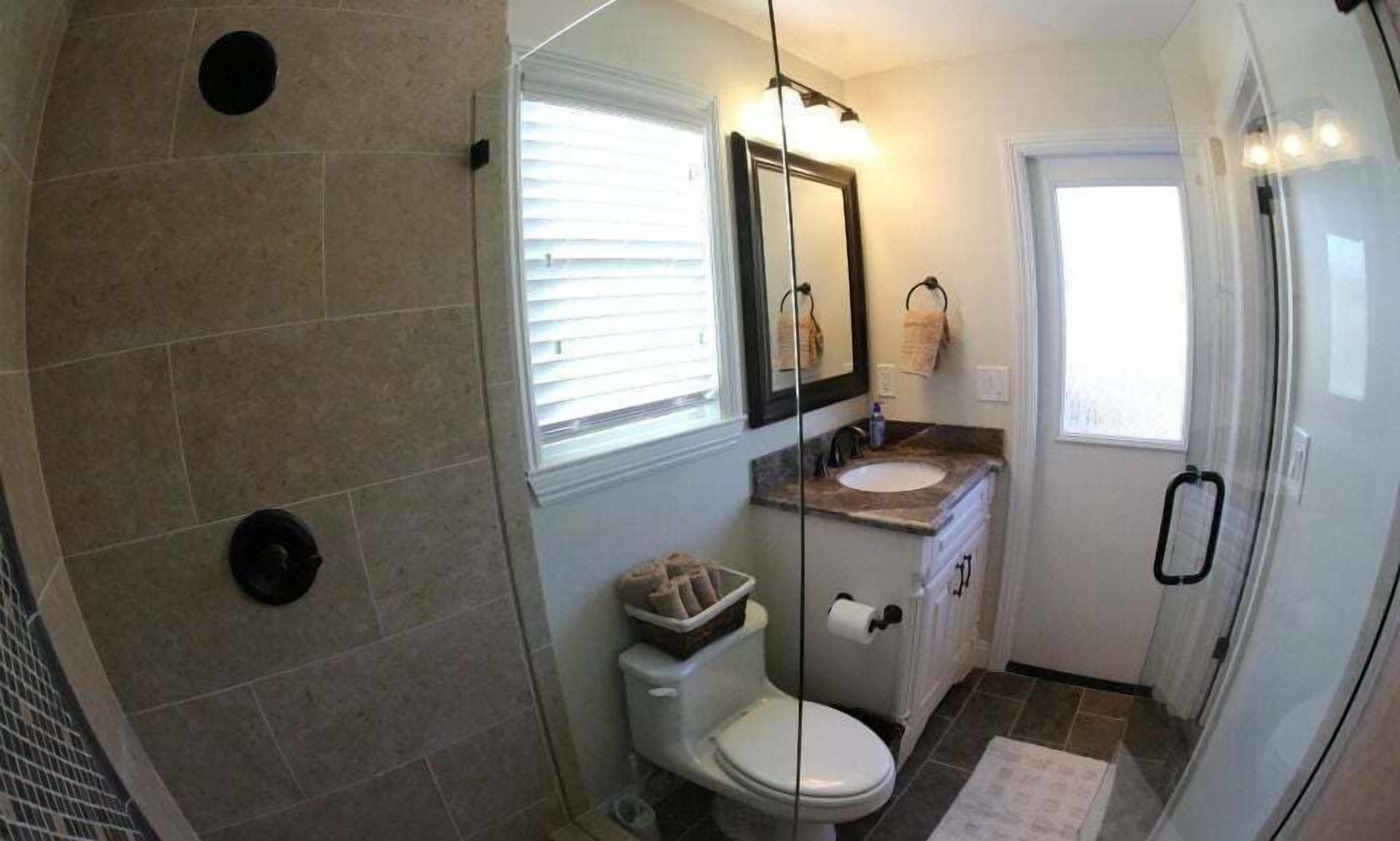 A bathroom with a toilet, sink, and shower.