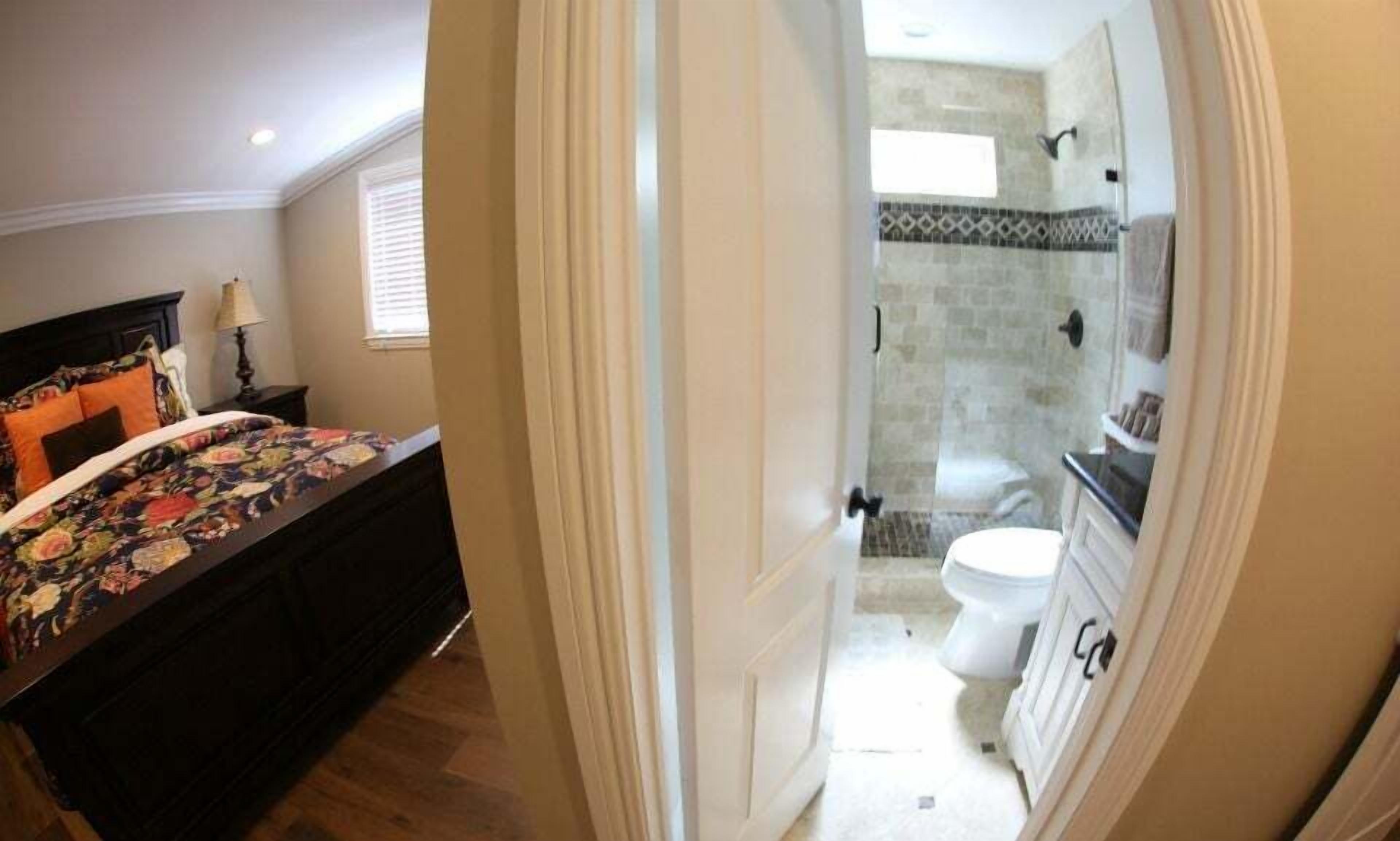 A bedroom with a bed, a nightstand, and a window.