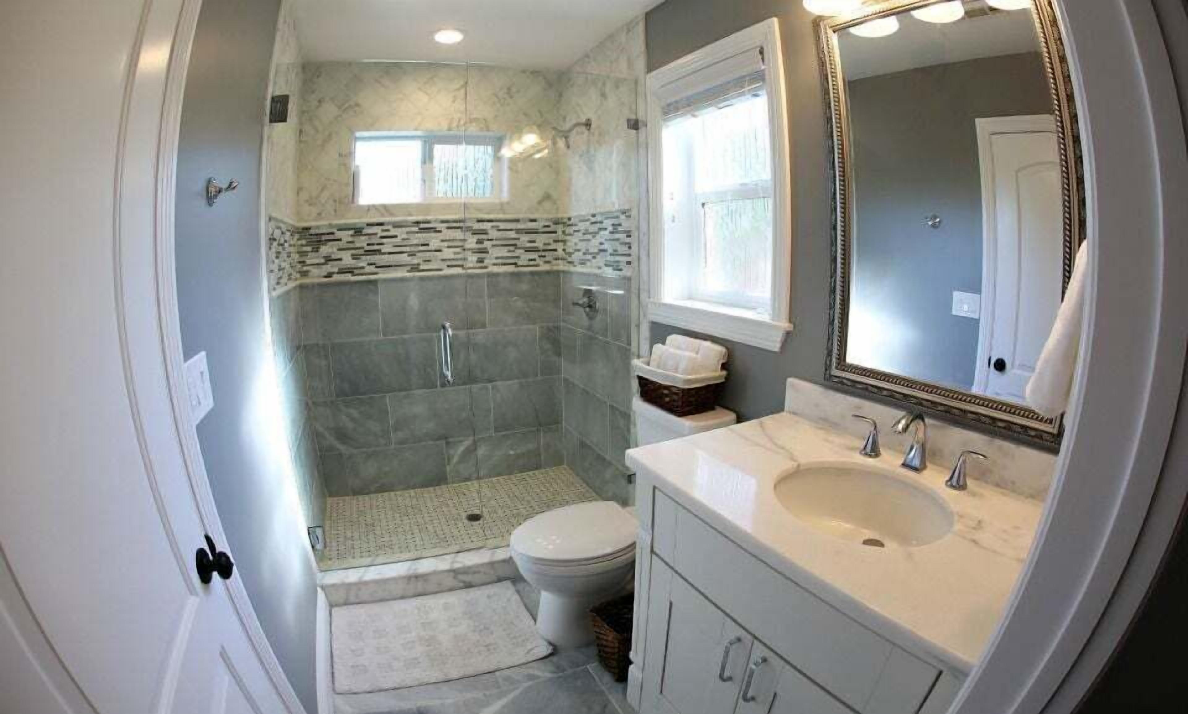 A bathroom with a walk-in shower, toilet, and sink.