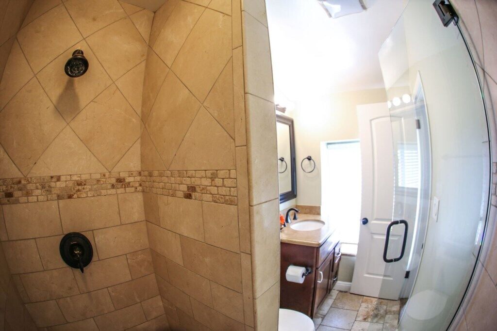 A bathroom with a shower, a sink, and a toilet.