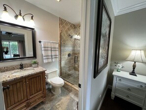 A bathroom with a vanity, a toilet, a shower with a glass door, and a mirror.