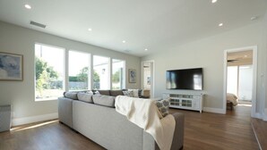 Un salón amplio con un sofá grande, un televisor y una chimenea.