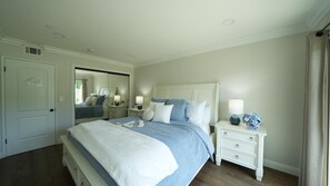 A bedroom with a large bed, bedside tables, a mirror, and a door. - Sensational 6 Bedroom 4 Bathroom Pool Home (3 Master Bedrooms W/bathrooms) (Anaheim)