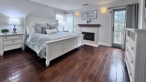 A bedroom with a large bed, a fireplace, a nightstand, and a dresser. - Fantastic 5 Bedroom 4 Bath Home With new Pool & Jacuzzi (Anaheim)