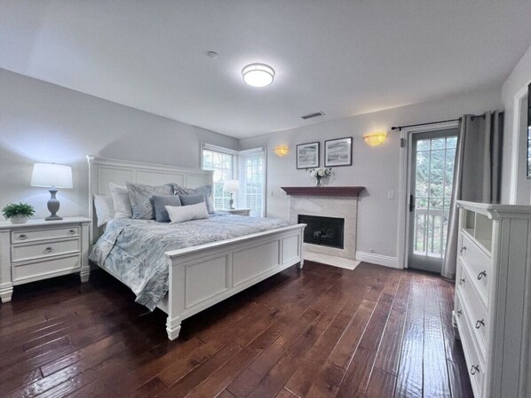 Une chambre à coucher avec un grand lit, une cheminée, une table de chevet et une commode.