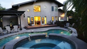 A house with a swimming pool, patio chairs, and a covered seating area. - Fantastic 5 Bedroom 4 Bath Home With new Pool & Jacuzzi (Anaheim)