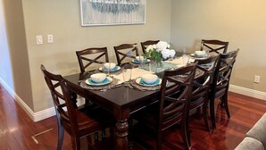 A dining area with a rectangular table set for six, surrounded by wooden chairs. - Amazing Large Family Home W/pool, 1 Mile to Disney (Anaheim)