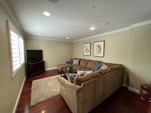 A living room with a sofa, coffee table, and a TV.