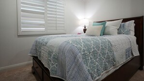A bedroom with a bed, a nightstand, a lamp, and a window with blinds. - Amazing Large Family Home W/pool, 1 Mile to Disney (Anaheim)