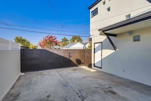 A gated driveway leading to a building with a garage door, a concrete driveway, and a clear sky. - 5 Bedroom plus loft room, 3 Bath home (Fullerton)