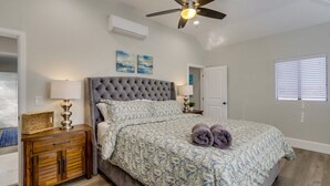 A bedroom with a tufted headboard, a bed with patterned bedding, a ceiling fan, and a window with blinds. - 5 Bedroom plus loft room, 3 Bath home (Fullerton)