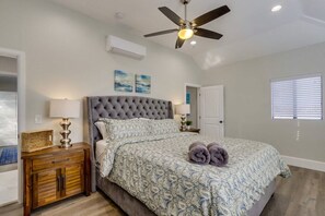 A bedroom with a tufted headboard, a bed with patterned bedding, a ceiling fan, and a window with blinds. - 5 Bedroom plus loft room, 3 Bath home (Fullerton)
