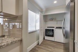 A compact kitchen with built-in appliances, a window with blinds, and a countertop. - 5 Bedroom plus loft room, 3 Bath home (Fullerton)