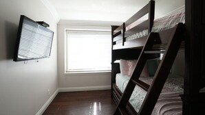 A bedroom with a bunk bed, a window with blinds, and a wall-mounted TV. - Awesome Pool Home 1/4 Mile To Disney Tram on Magic Way (Anaheim)
