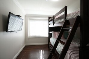 A bedroom with a bunk bed, a window with blinds, and a wall-mounted TV. - Awesome Pool Home 1/4 Mile To Disney Tram on Magic Way (Anaheim)