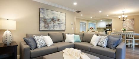 A living room with a grey sectional sofa, a coffee table, and a lamp.